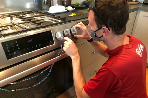 Affordable range repair technician fixing a kitchen appliance in Philadelphia PA