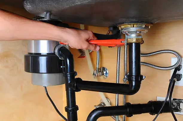 Garbage disposal repair technician fixing a sink disposal in Philadelphia PA