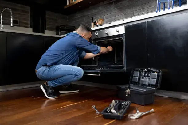 Electric dryer repair technician fixing a dryer in Philadelphia PA