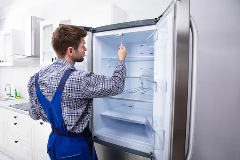 Fridge repair technician checking a refrigerator in Philadelphia PA