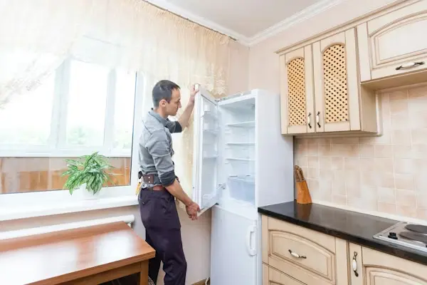 Alt Text: Freezer repair technician checking an upright freezer in Philadelphia PA