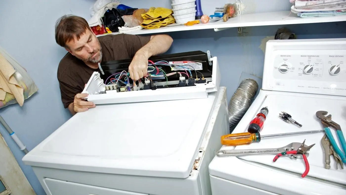 Dryer taking too long to dry repair technician inspecting a dryer in Philadelphia PA