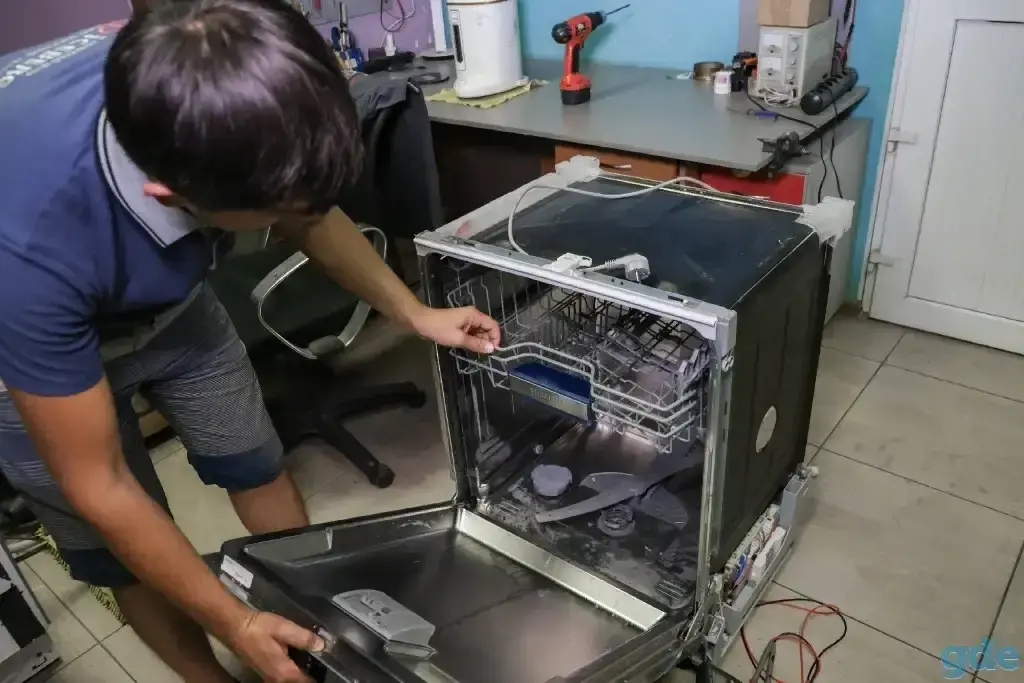 Local dishwasher repair technician inspecting a dishwasher in Philadelphia PA