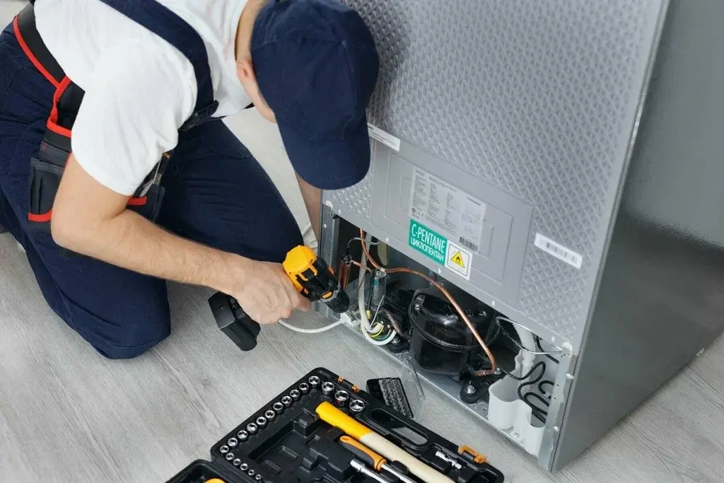 Refrigerator making noise repair technician checking the back of a fridge in Philadelphia PA