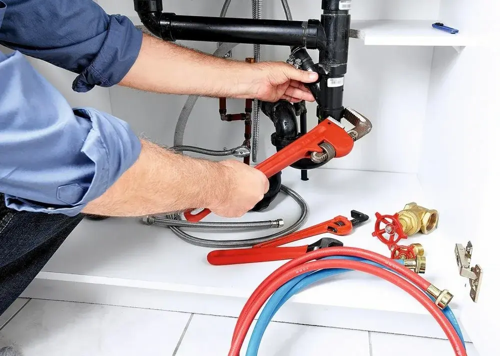 Local garbage disposal repair technician inspecting a sink disposal in Philadelphia PA