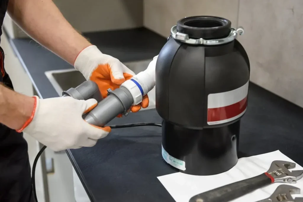 Garbage disposal repair technician servicing a kitchen disposal in Philadelphia, PA